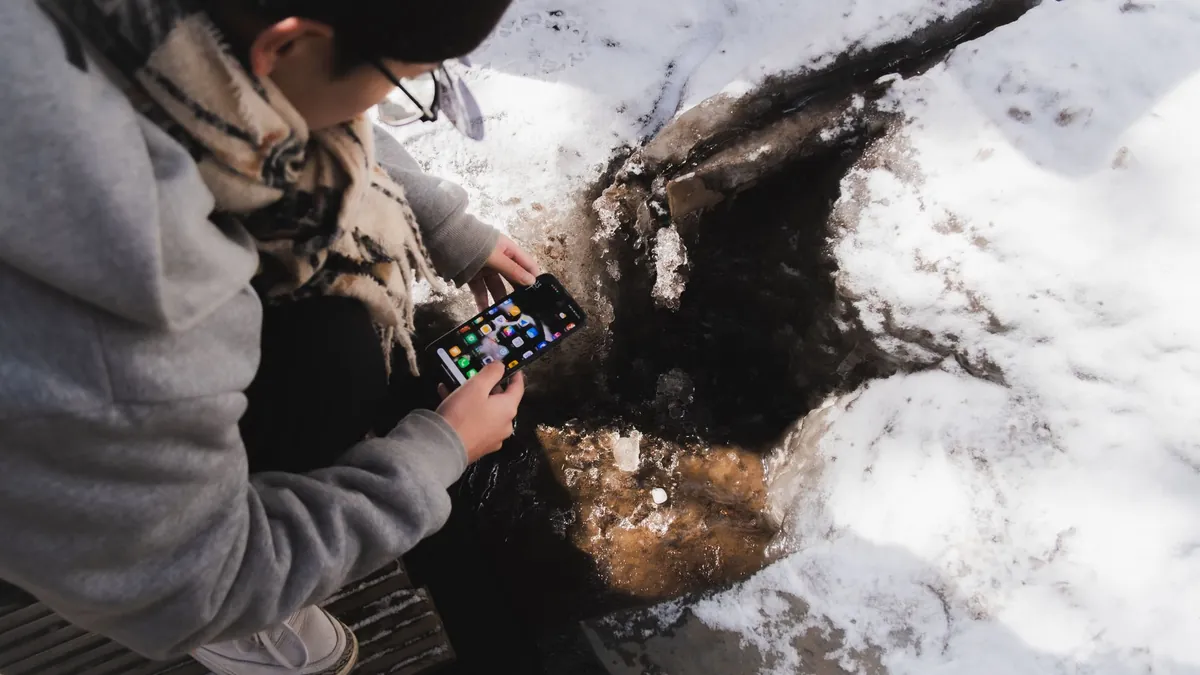 Soğuk havada telefon kapanıyor: karda telefon kullanan kişi